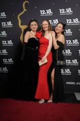 A group of smiling women posing for a photo at an event, possibly a premiere or red carpet event, with a luxurious and elegant atmosphere. The image is associated with 12. 18. Investment Management GmbH, as per the context.