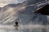 Frau schwimmt im Pool mit Berg im Hintergrund