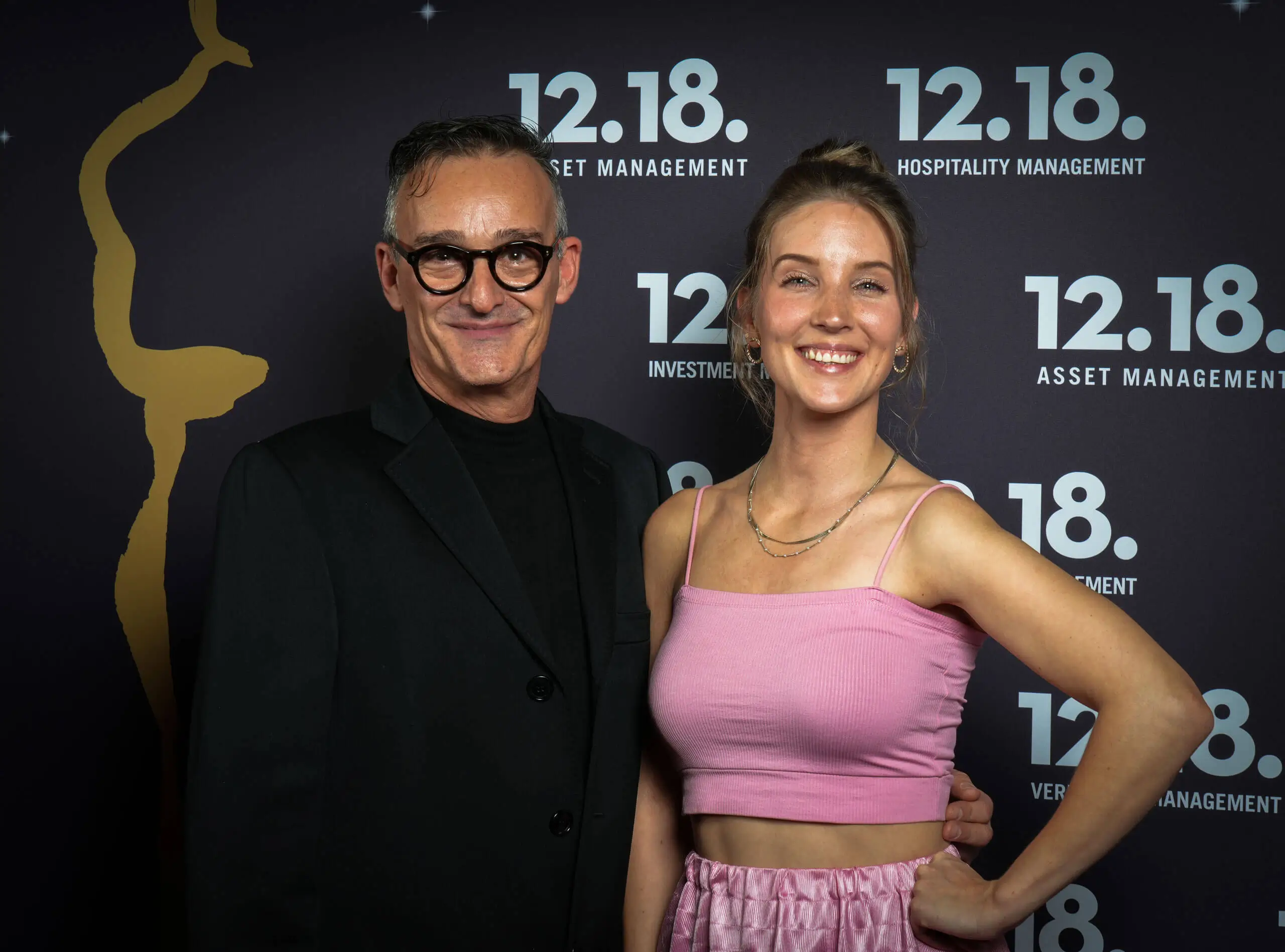 Zwei lächelnde Personen bei einer formellen Veranstaltung, die Eleganz und Feierlichkeit zeigen.