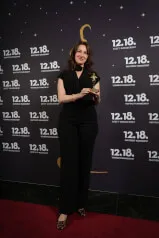 A woman in a black suit holding a trophy at 12. 18. Investment Management GmbH, based on the information from https://12-18.com