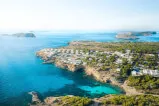 Ein Panoramablick auf eine Stadt auf einer felsigen Insel, der die unberührte Naturlandschaft zeigt, wie sie für das 7Pines Resort Ibiza typisch ist.