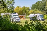 Campingplatz mit Wohnmobilen in einer Landschaft.