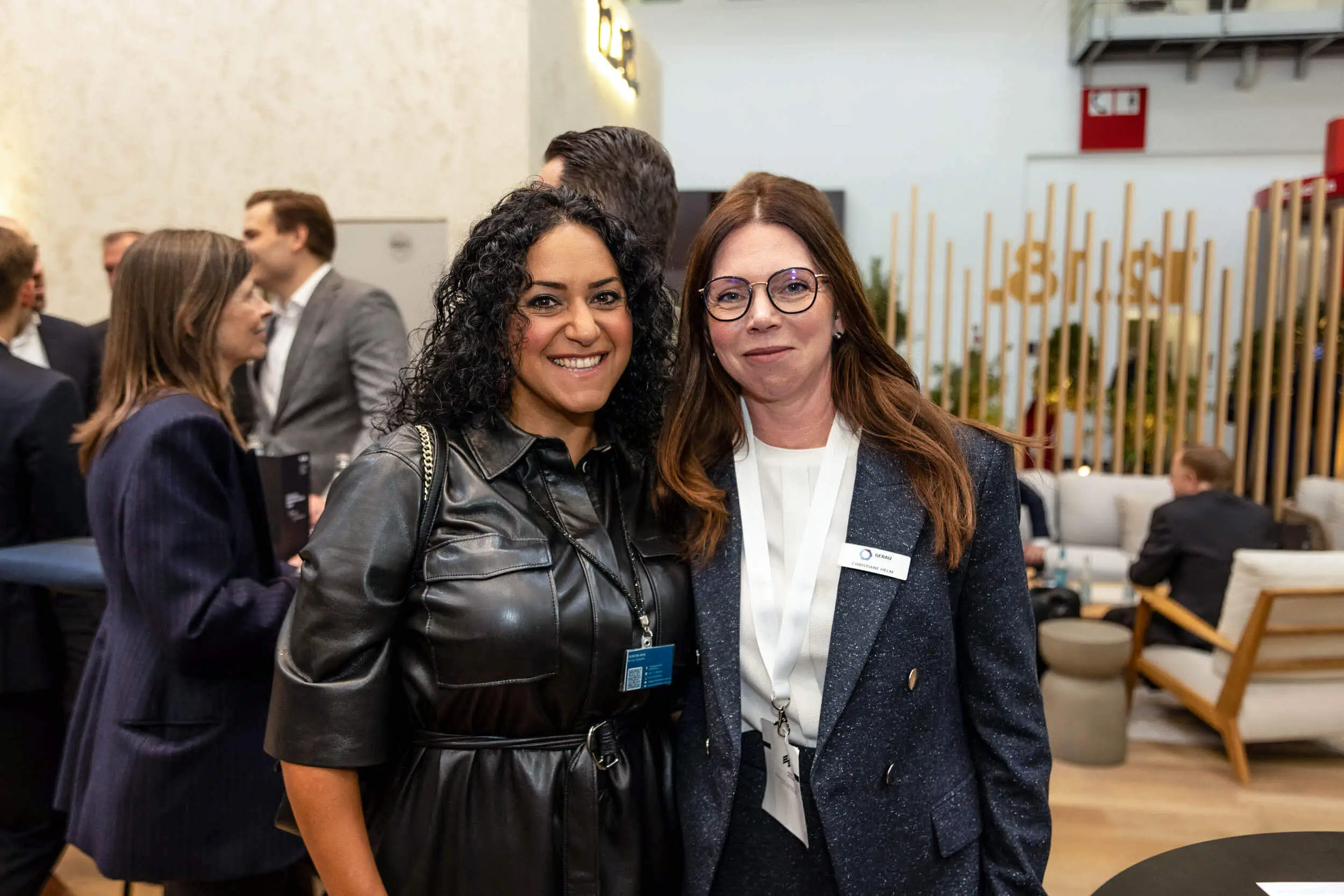 Zwei Frauen lächeln bei einer Networking-Veranstaltung im Expo-Kontext.