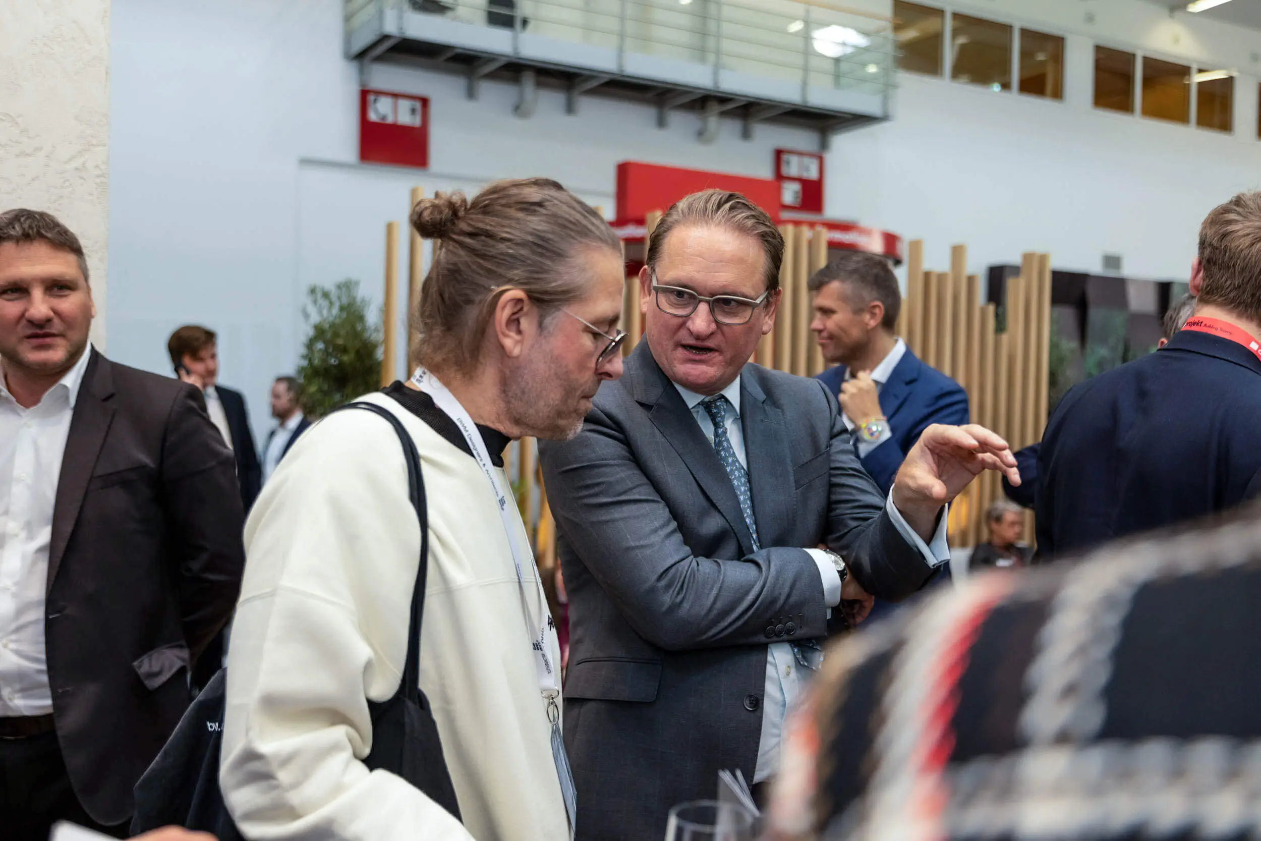Fachleute im Anzug netzwerken auf einer Messe.