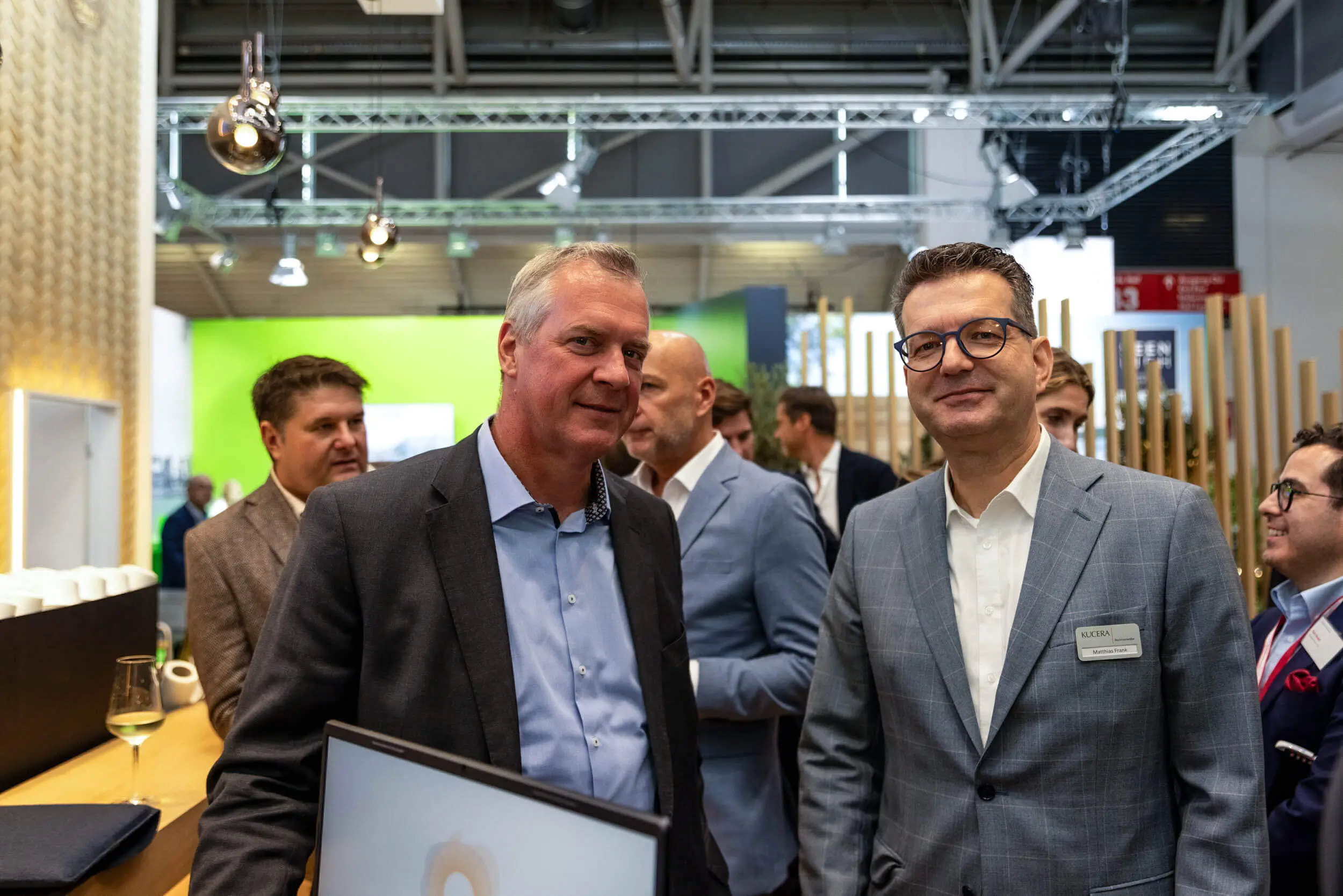 Zwei Geschäftsleute sprechen auf einer Messe im Ausstellungsbereich.
