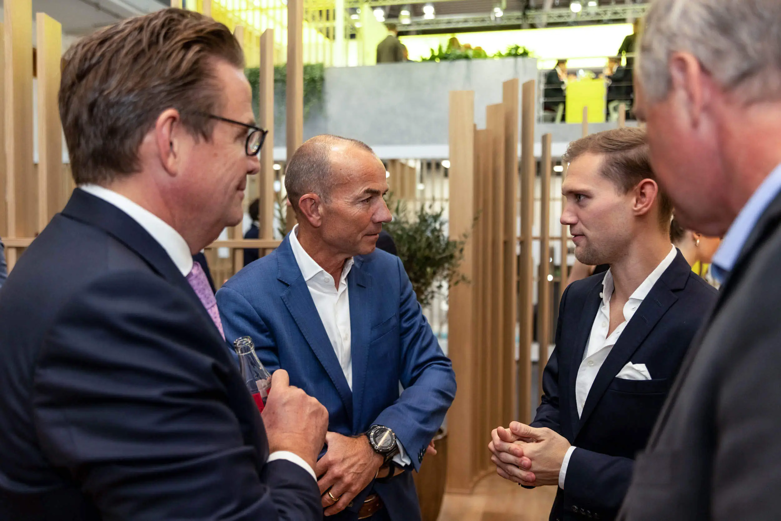 Vier Geschäftsleute im Gespräch auf einer Expo.