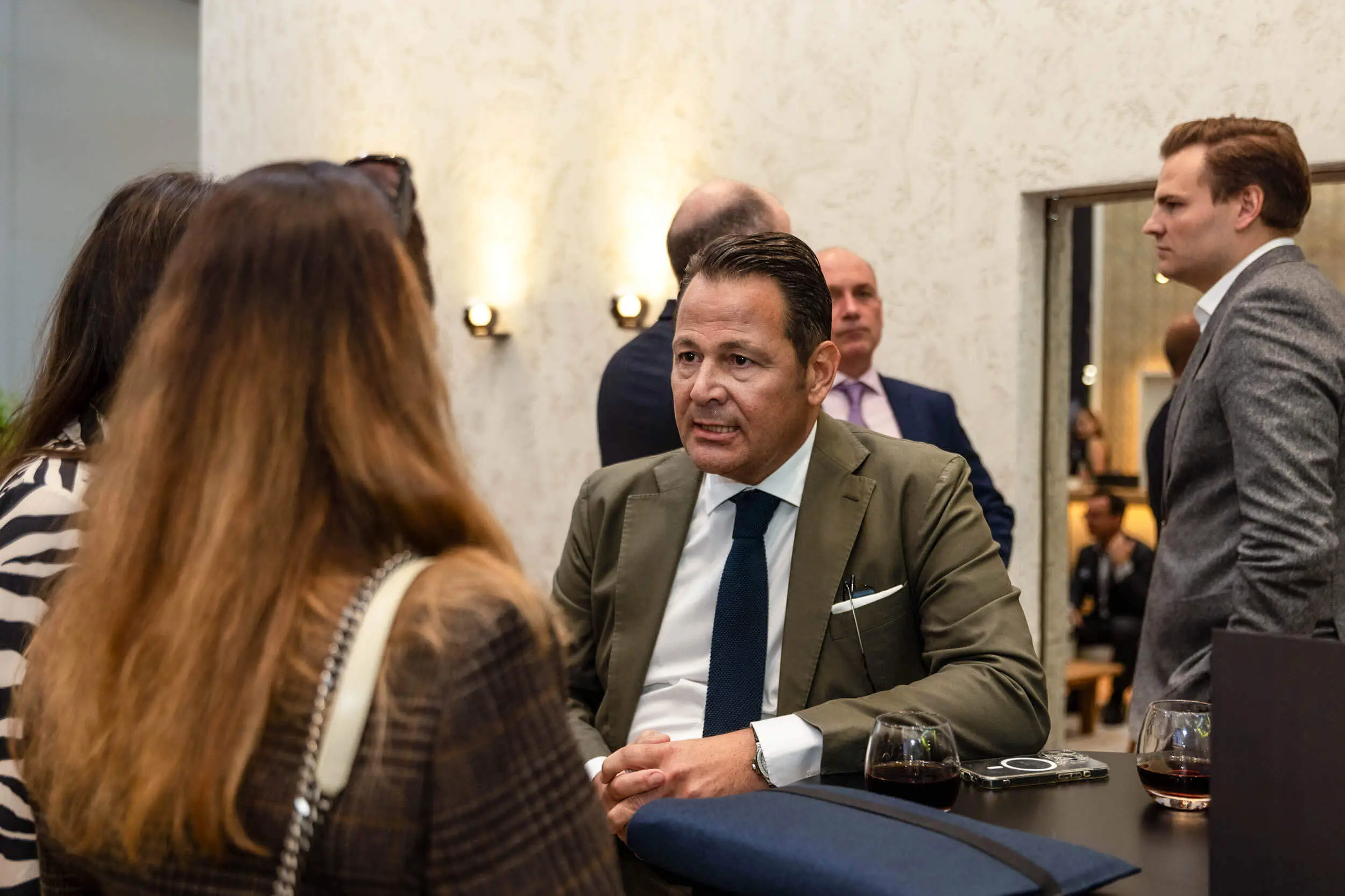 Netzwerktreffen mit Fachleuten, die bei Getränken diskutieren.