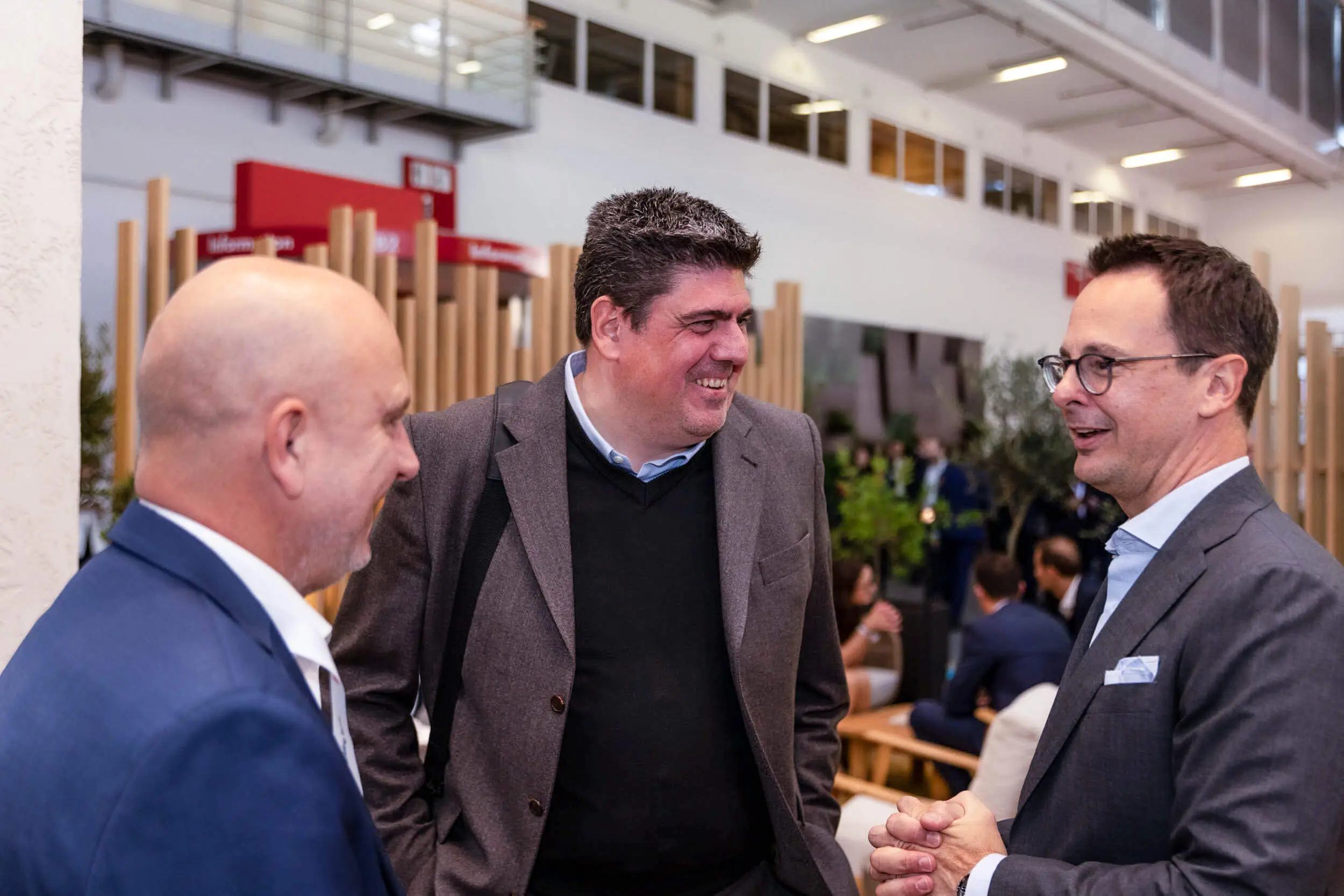 Drei Männer unterhalten sich auf einer Fachveranstaltung.