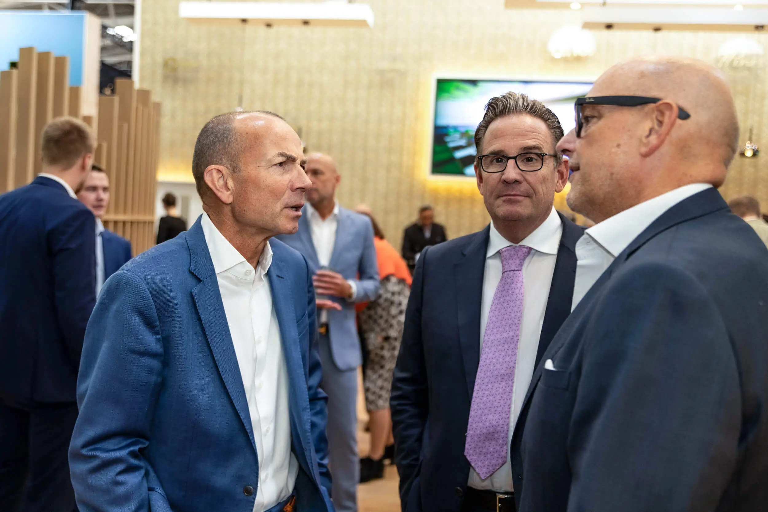 Drei Geschäftsleute unterhalten sich auf einer Expo.