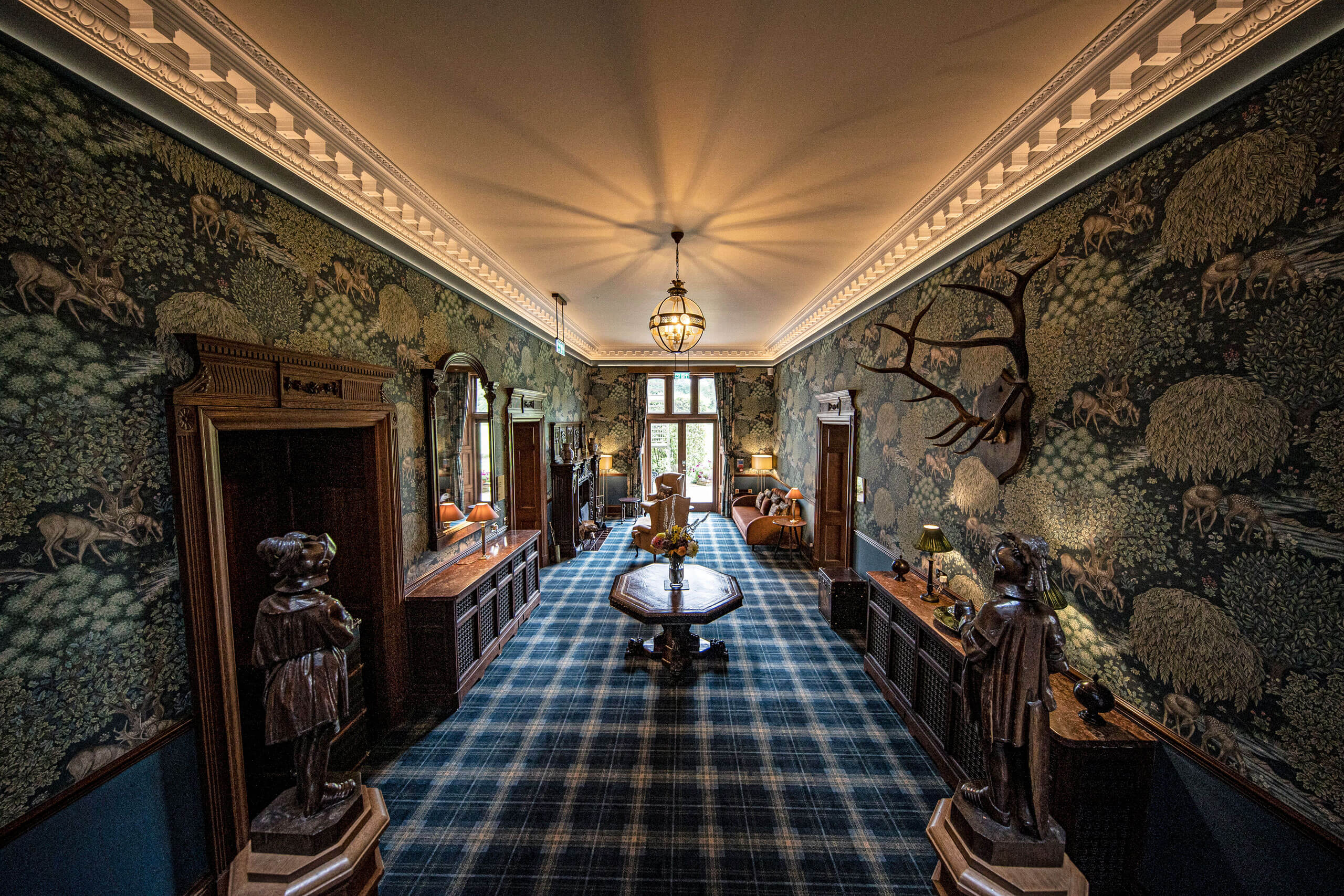 A room with a blue plaid carpet and a table with statues