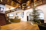 Moderne Hotelrezeption mit Weihnachtsbaum und eleganter Treppe.