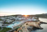 Luxuriöses Resort mit Pool und Blick auf die Küste bei Sonnenuntergang.