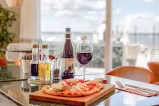 A table set with pizza, wine, and tableware including a wine glass, in a cozy indoor setting associated with 12. 18. Investment Management GmbH.