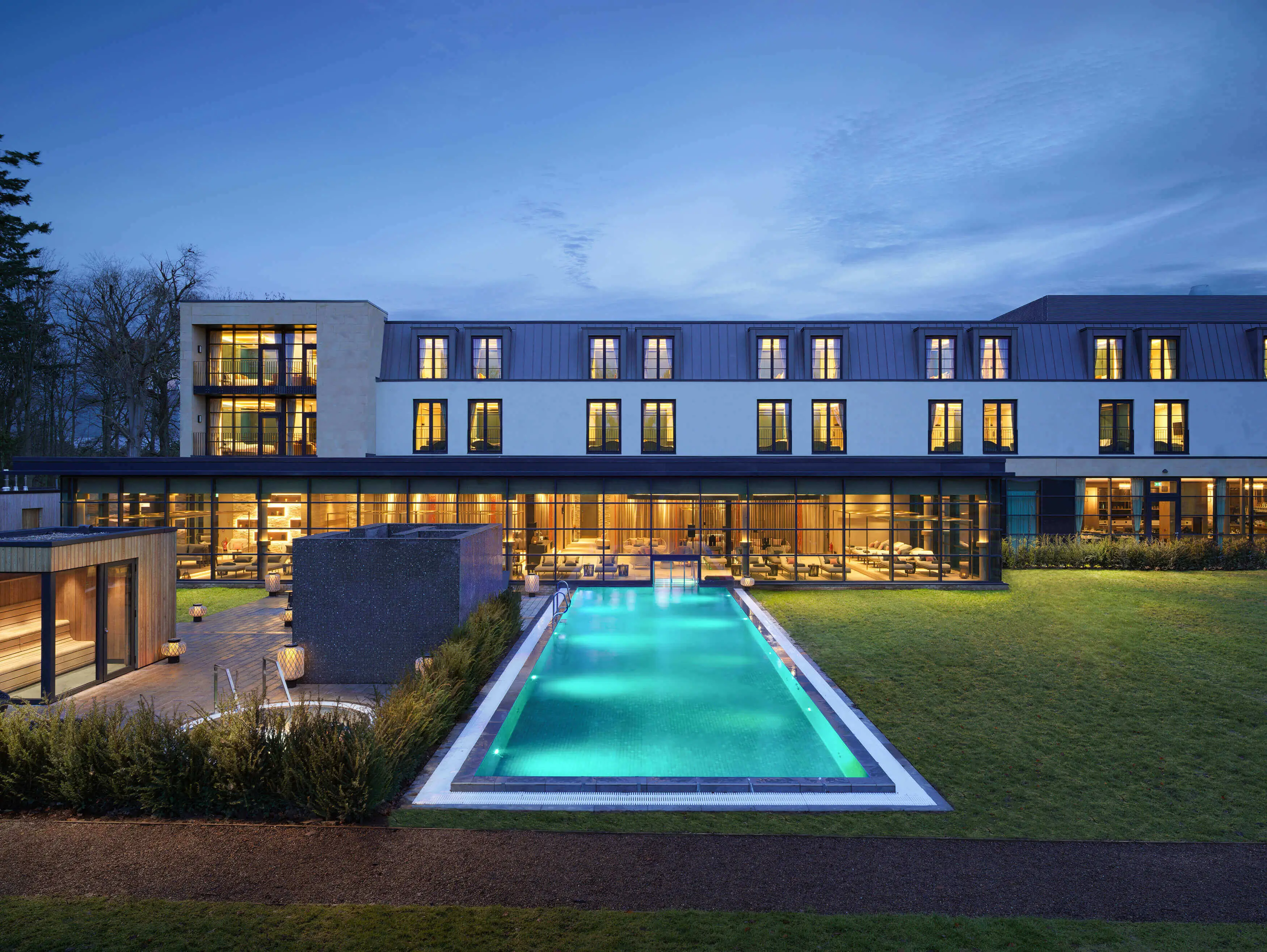 A pool in front of a building in a scenic environment