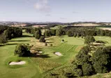 Ein malerischer Golfplatz mit Bäumen und Hügeln