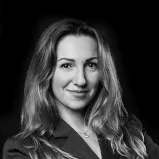 A professional woman with long hair wearing a suit on the website of 12. 18. Investment Management GmbH