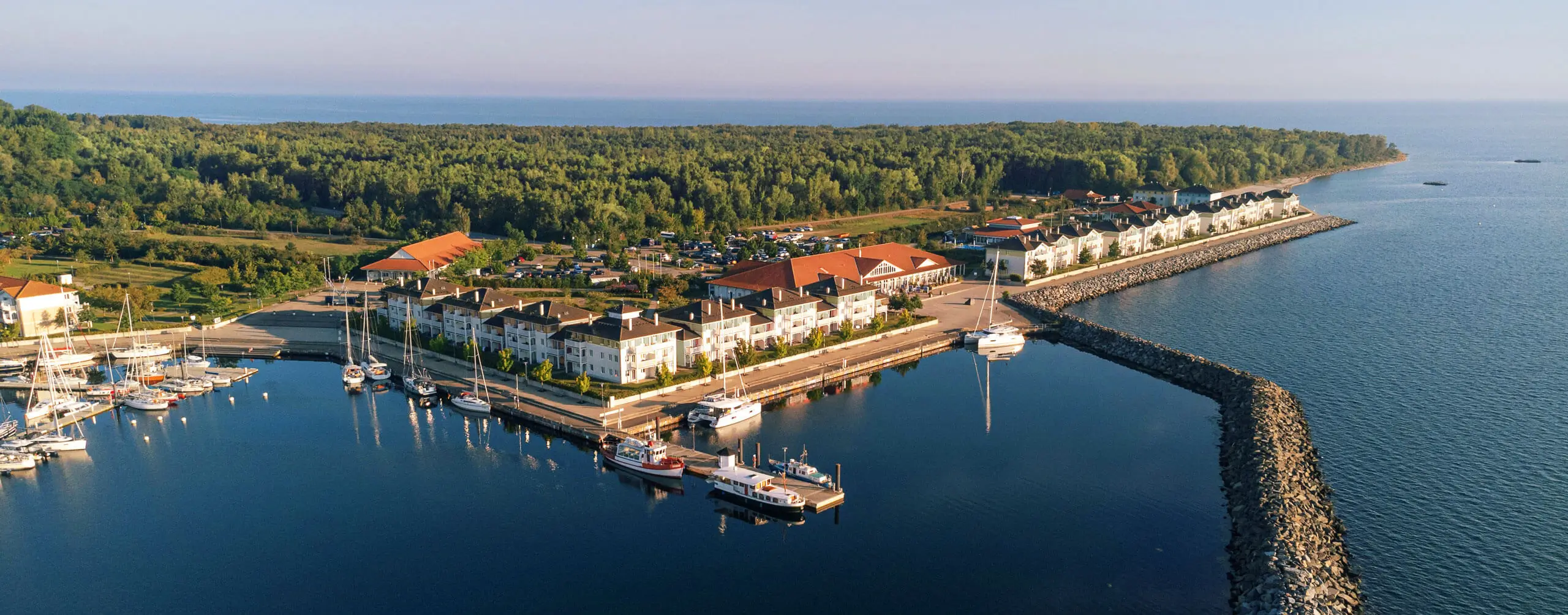 A scenic marina with boats and green landscapes at a picturesque waterfront.