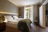 Gemütliches Bett mit grüner Decke in einem Zimmer, ideal für touristische Immobilien.