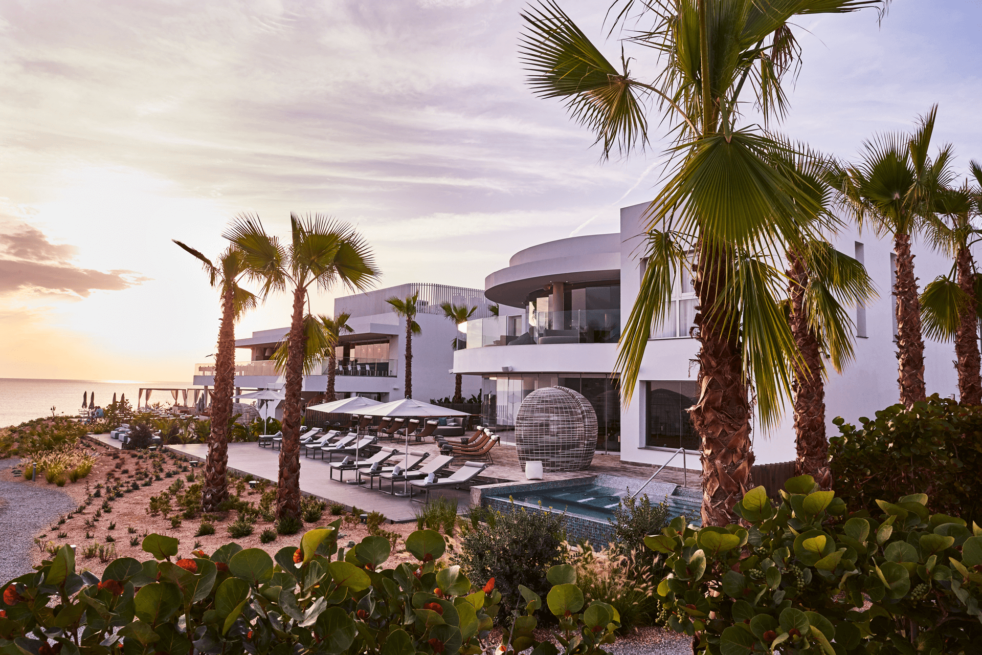 A peaceful poolside view with a building and palm trees