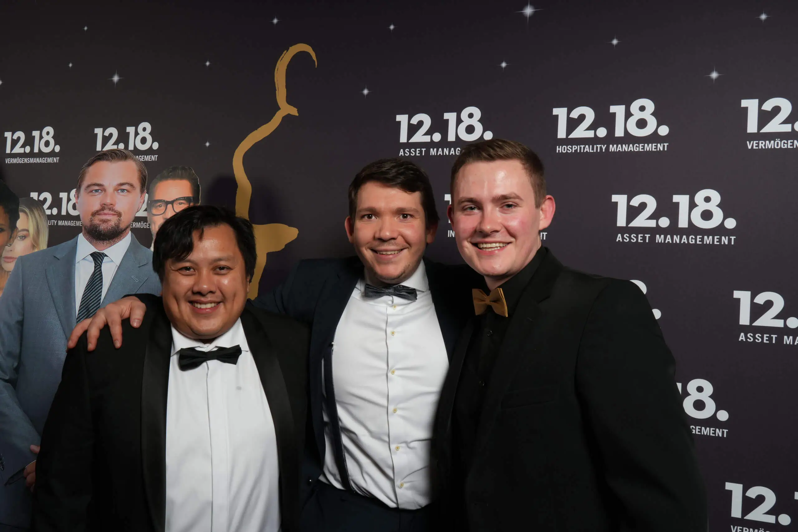 Drei Männer in Smoking bei einem glamourösen Event für 12.18 Asset Management.