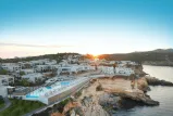 Luxuriöses Resort am Meer mit modernem Pool und Sonnenuntergang.