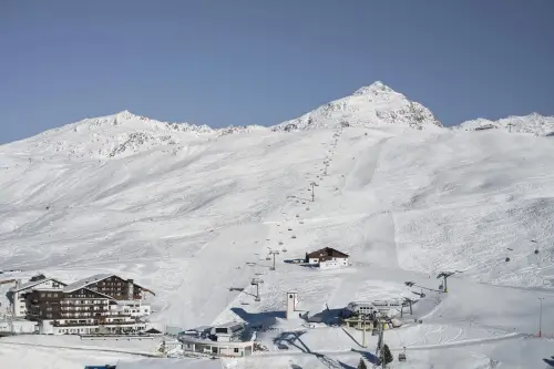 Skigebiet mit schneebedecktem Berg und Skiliften.