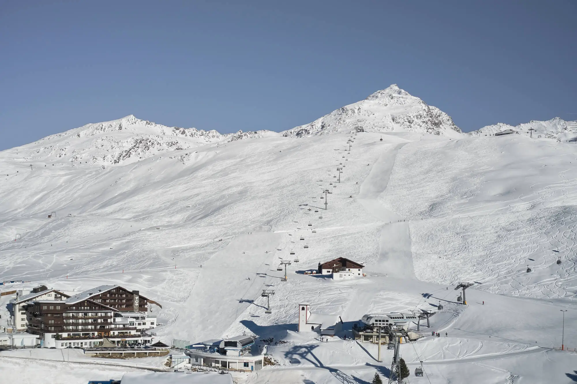 Schneebedeckte Berge mit einer Hotelanlage und Ski-Liften in der Skiregion.