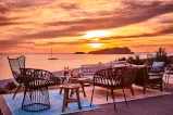 Essen im Freien mit Cocktails und Blick auf einen wunderschönen Sonnenuntergang am Strand.