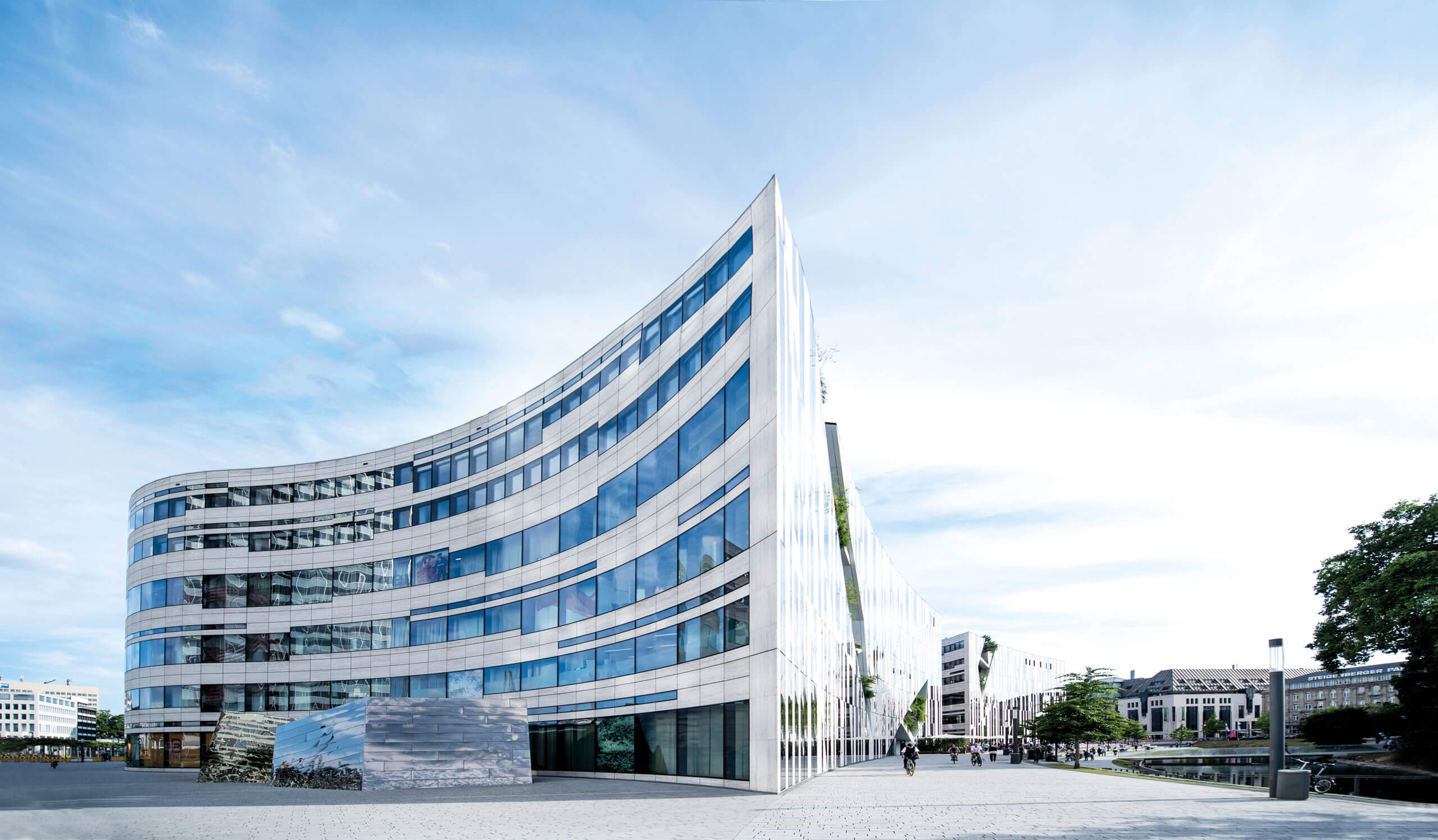 Ein Gebäude mit gebogenen Glasfenstern im Kontext von 12.18. Investment Management GmbH mit Sitz in