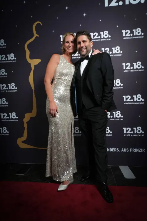 Glamouröse Abendveranstaltung mit einer Frau in einem silbernen Kleid und einem Mann im Smoking.