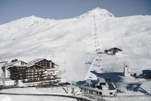 Schneebedeckte Berglandschaft mit Skiliften und einem Hotel, ideal für Wintersport.
