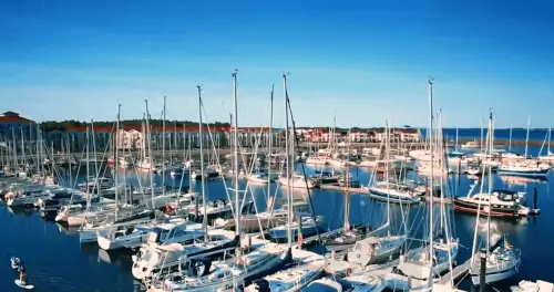 Ein lebendiger Yachthafen mit Booten und klarem blauen Himmel im BEECH Resort Boltenhagen, ideal für einen Strandurlaub.